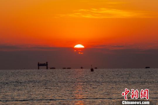  资料图：一轮红日从海里冒出。肖丁 摄