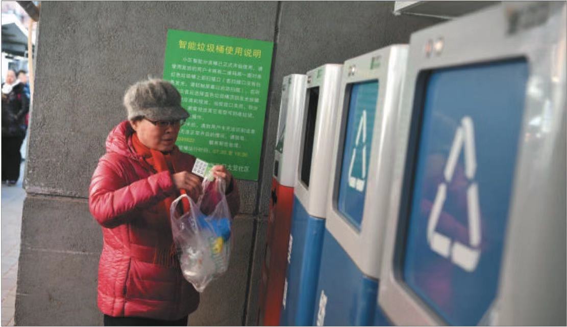  12月4日下午，西城区大乘巷教师宿舍院，一位居民刷卡把垃圾投入对应的垃圾箱内。摄影/新京报记者 吴江