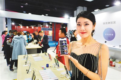 11月15日，2019日韩（青岛）进口商品博览会上，工作人员展示5G手机。王海滨摄（人民视觉）