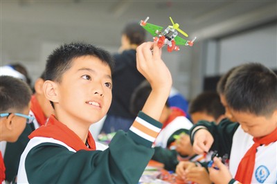 10月21日，学生在青岛国际机器人中心动手体验安装螺旋桨飞机。王海滨摄（人民视觉）