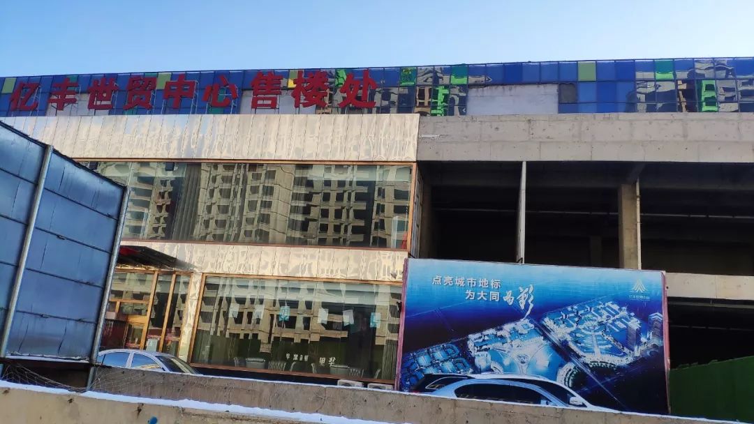 经过简单装修的售楼处与旁边空洞的主体结构形成鲜明对比,这场徘徊多年的烂尾困局至今未有终点。