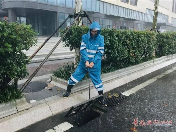 △青岛水务排水公司事情职员防汛值守积水点,实时排水,包管门路流通。记者 吴帅摄