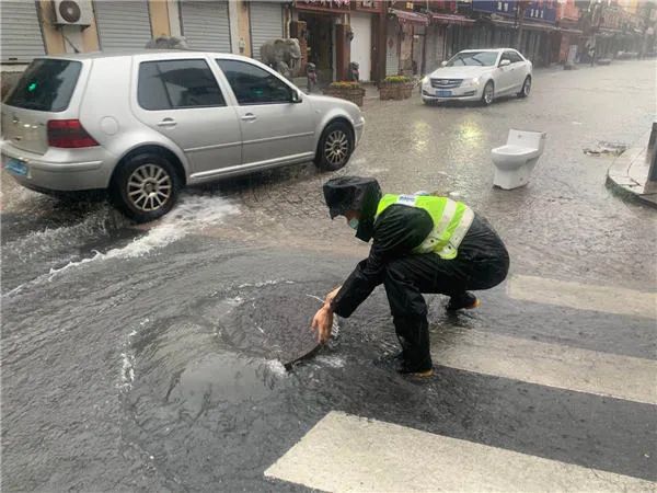 △市南交警打开井盖加快排水。