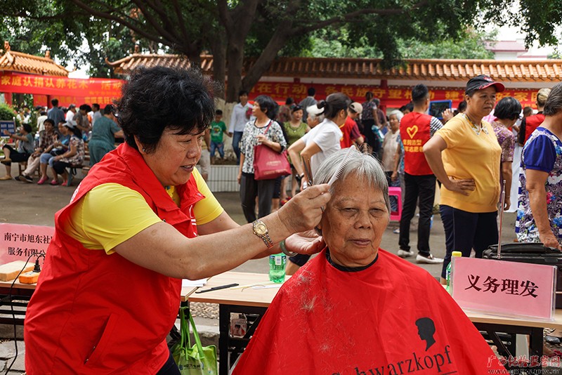 天下三八红旗头南宁旭店主政办事公司首创人王旭东任务为老人剃头。(南宁市纪委监委驻市工信局纪检监察组供图张碧仙/摄)