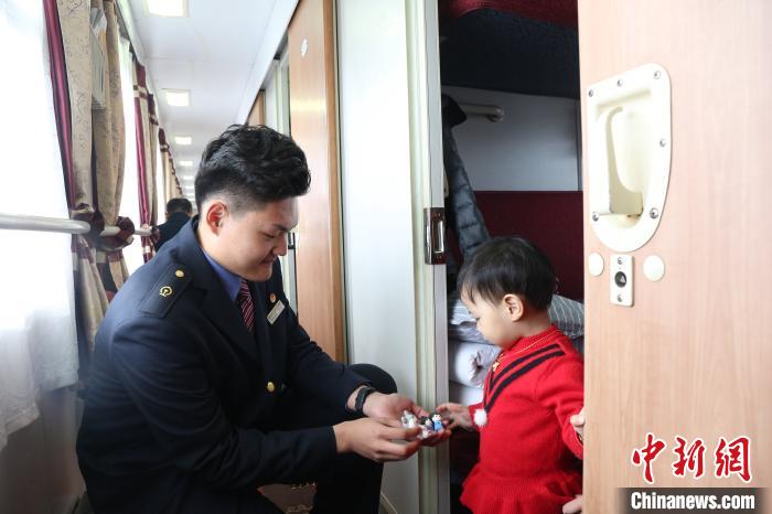 乘务人员捏制卡通吉祥物,送给乘车小旅客。 方正 摄