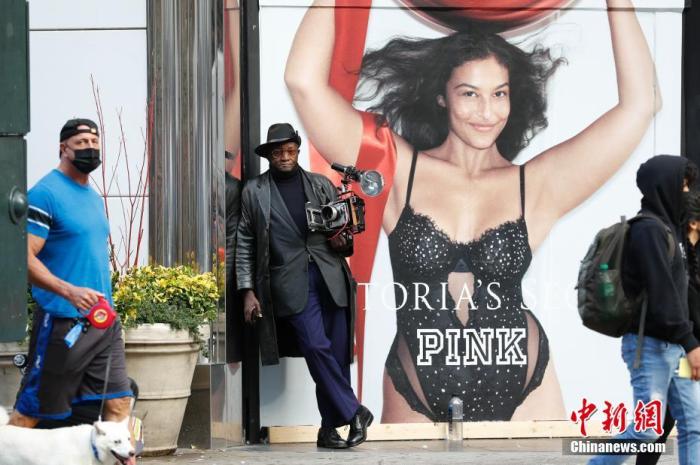 当地时间11月26日,美国传统节日感恩节,一位摄影师在纽约梅西百货公司旁等待为人们提供胶片摄影服务。 中新社记者 廖攀 摄