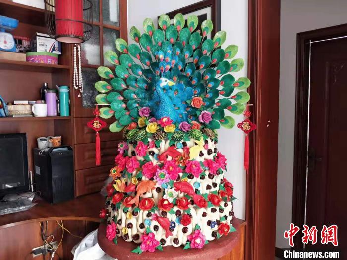 在卫兴安家中的一处角落,三层花馍顶端那只色彩艳丽的蓝孔雀让人惊叹不已,每片羽毛上的纹路都看得很清楚。 杨佩佩 摄
