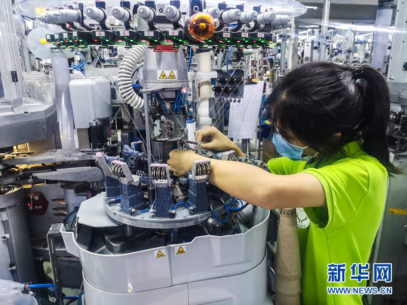 工人在袜业扶贫车间智能袜机生产线上作业.新华网 张潘 摄