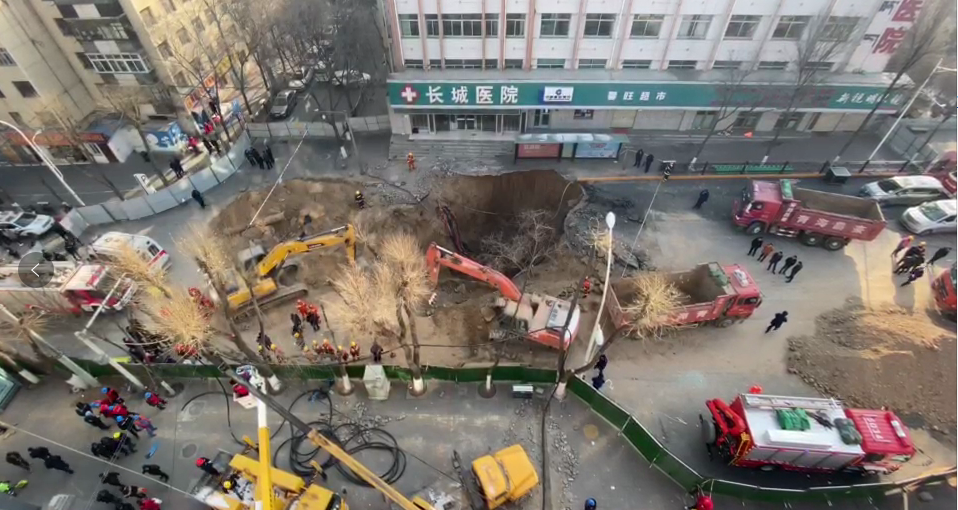 挖掘机正在坑洞中挖掘救援。 新京报“我们视频”截图