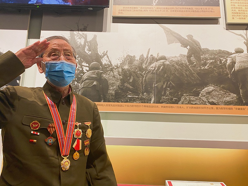 在纪念中国人民志愿军抗美援朝出国作战70周年主题展览上，杜文亮与自己拍摄的作品合影（10月27日摄）。新华社记者 任沁沁 摄