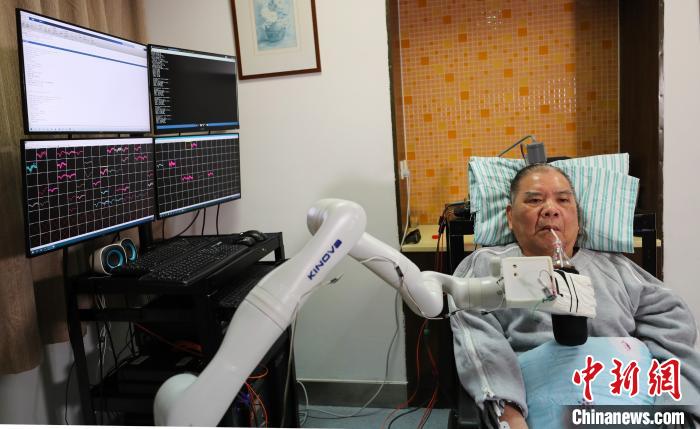 图为高位截瘫患者张先生用“意念”喝可乐 浙大供图 摄