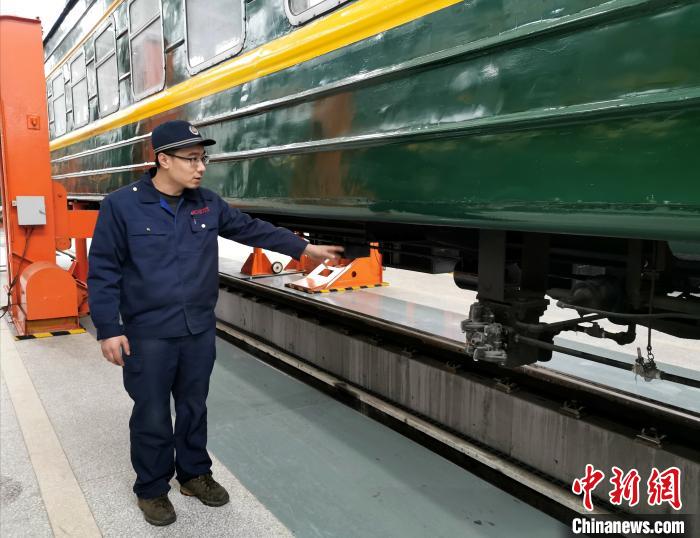 信松向记者介绍旅客列车制动阀。 杨杰英 摄