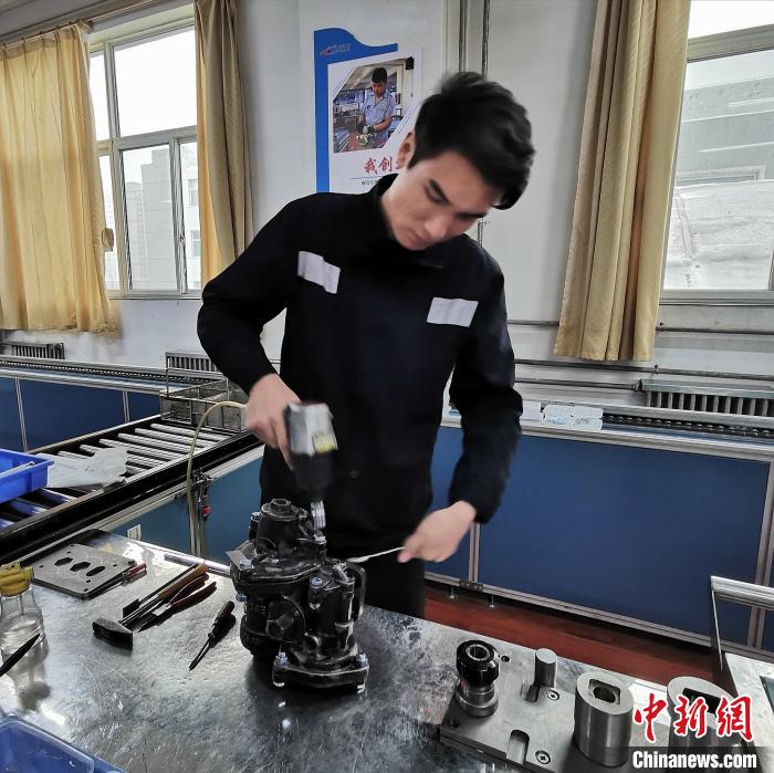 “90后”张豫栋正在对旅客列车制动阀进行检修。 杨杰英 摄