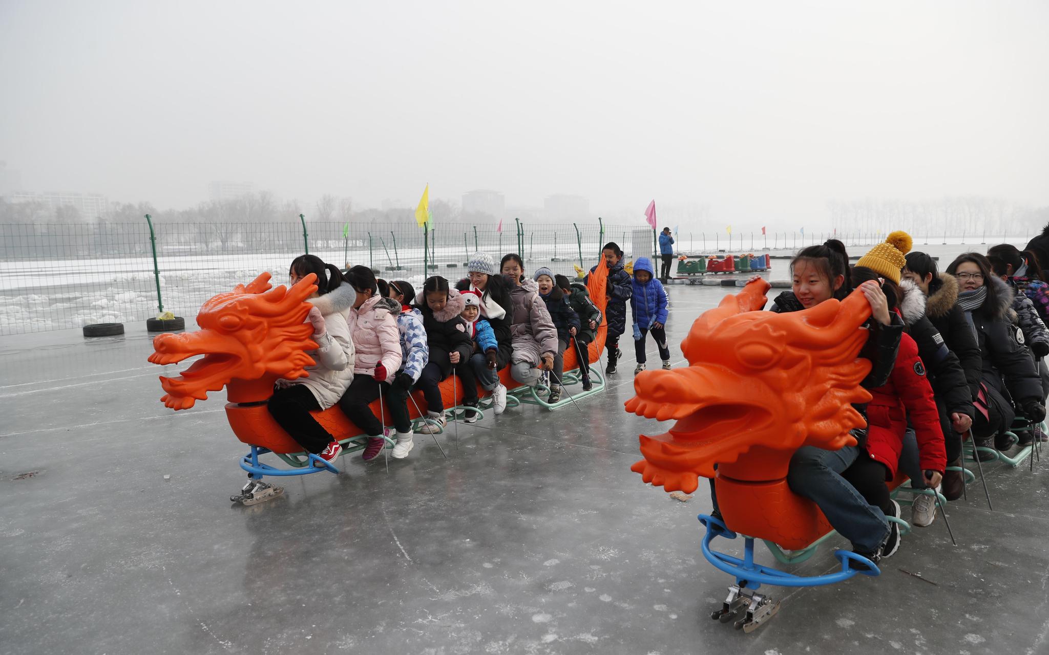 小游客们在冰上开展“冰上龙舟赛”。新京报记者 侯少卿 摄