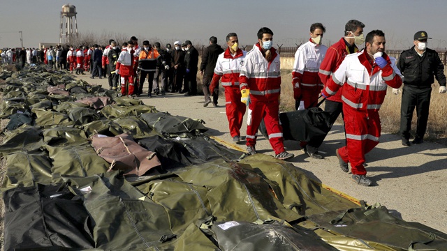 乌克兰客机坠毁后，搜救队搬运着遇难者遗体 图自 美联社