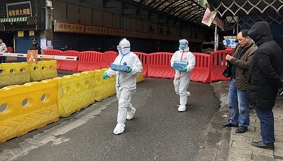 身着白色防护服装的工作人员在现场采样。 摄影：界面新闻记者曾金秋