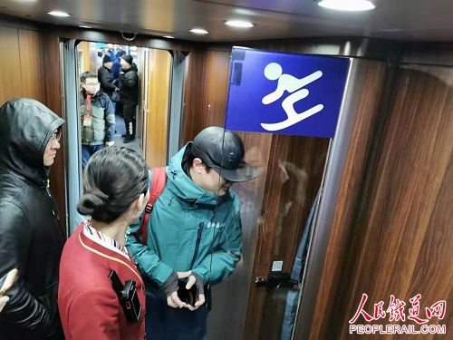 △列车上，工作人员在为滑雪爱好者讲解滑雪设备存放区的使用方法。