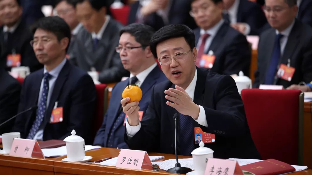 2019年全国两会上，罗佳明手拿橘子介绍眉山春橘产业。新京报记者 薛珺 摄