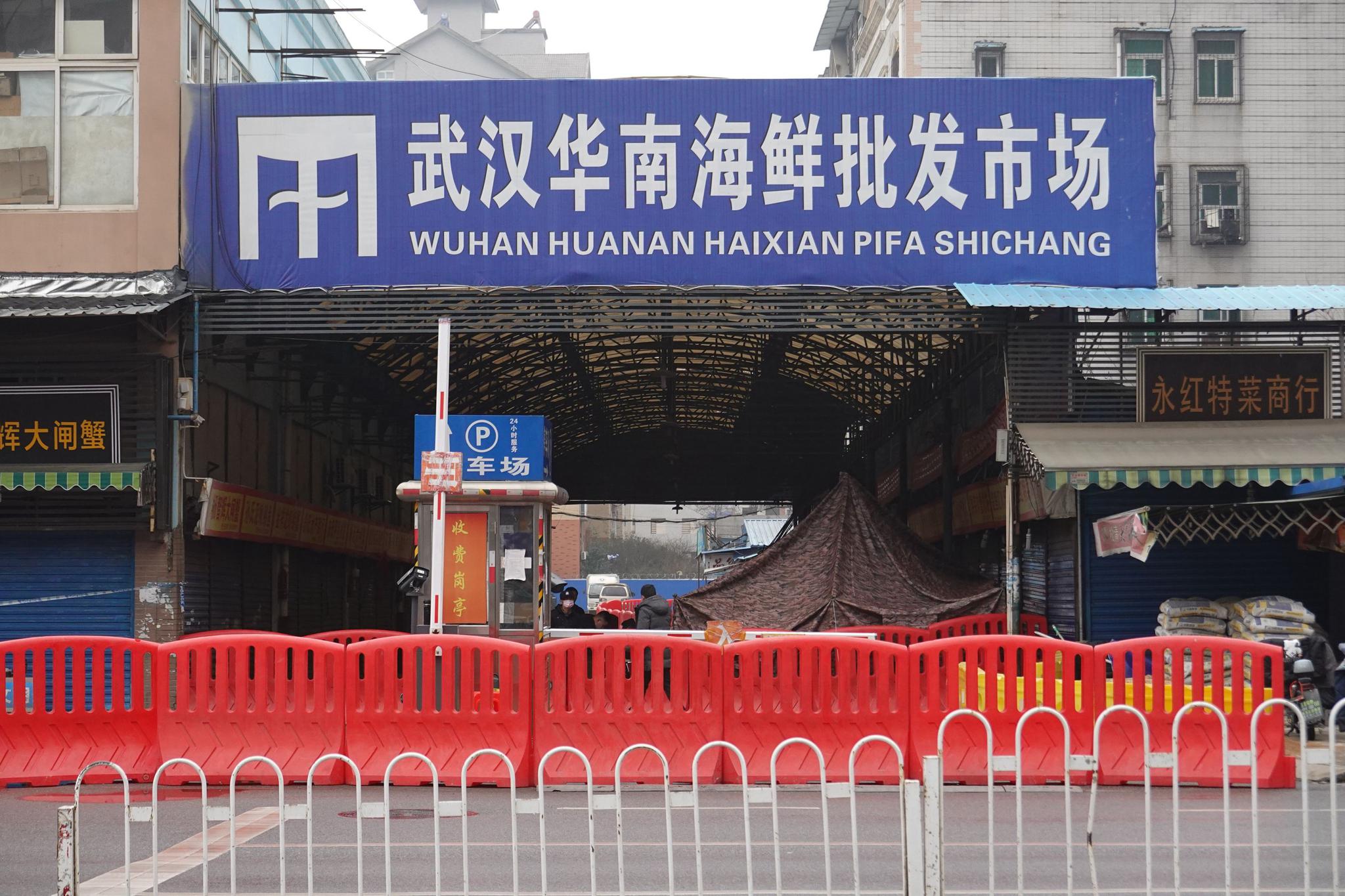 1月21日16时许,武汉华南海鲜批发市场大门西南侧东区五街通道已关停,当地警方在现场拉起警戒线。新京报记者 游天燚 摄
