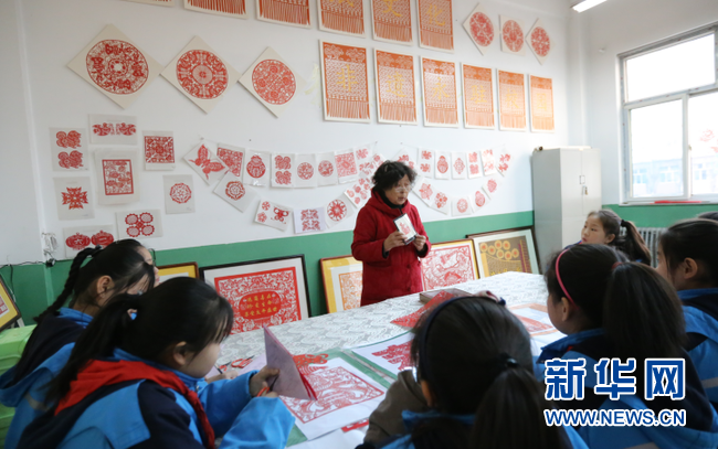 冯金兰向学生们讲解剪纸文化。新华网 武斌 摄