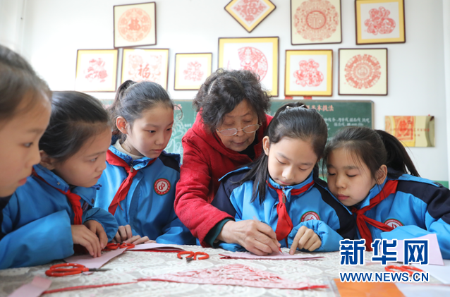 冯金兰在平定县东关小学教授剪纸。新华网 武斌 摄