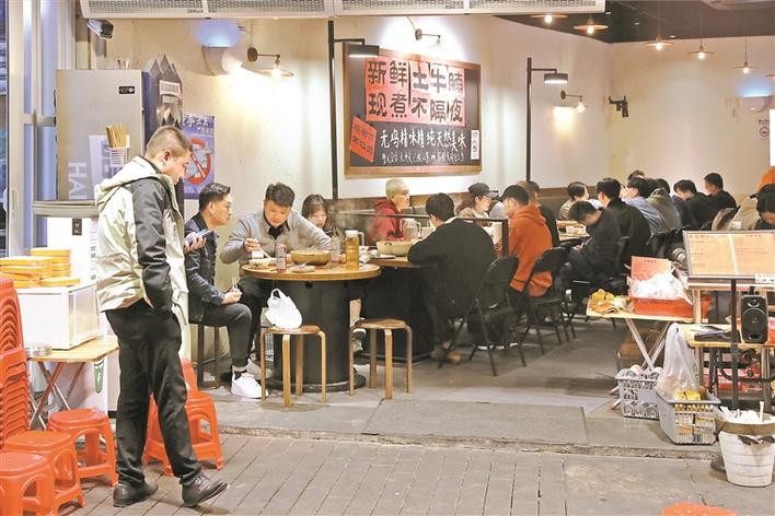 ▲夜幕降临,街边餐饮店吸引了不少市民前来吃夜宵。