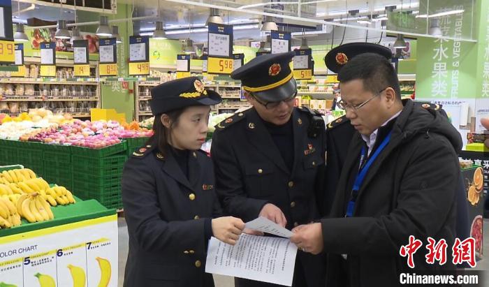 市场监管工作人员在向超市负责人宣讲相关规定 张践 摄