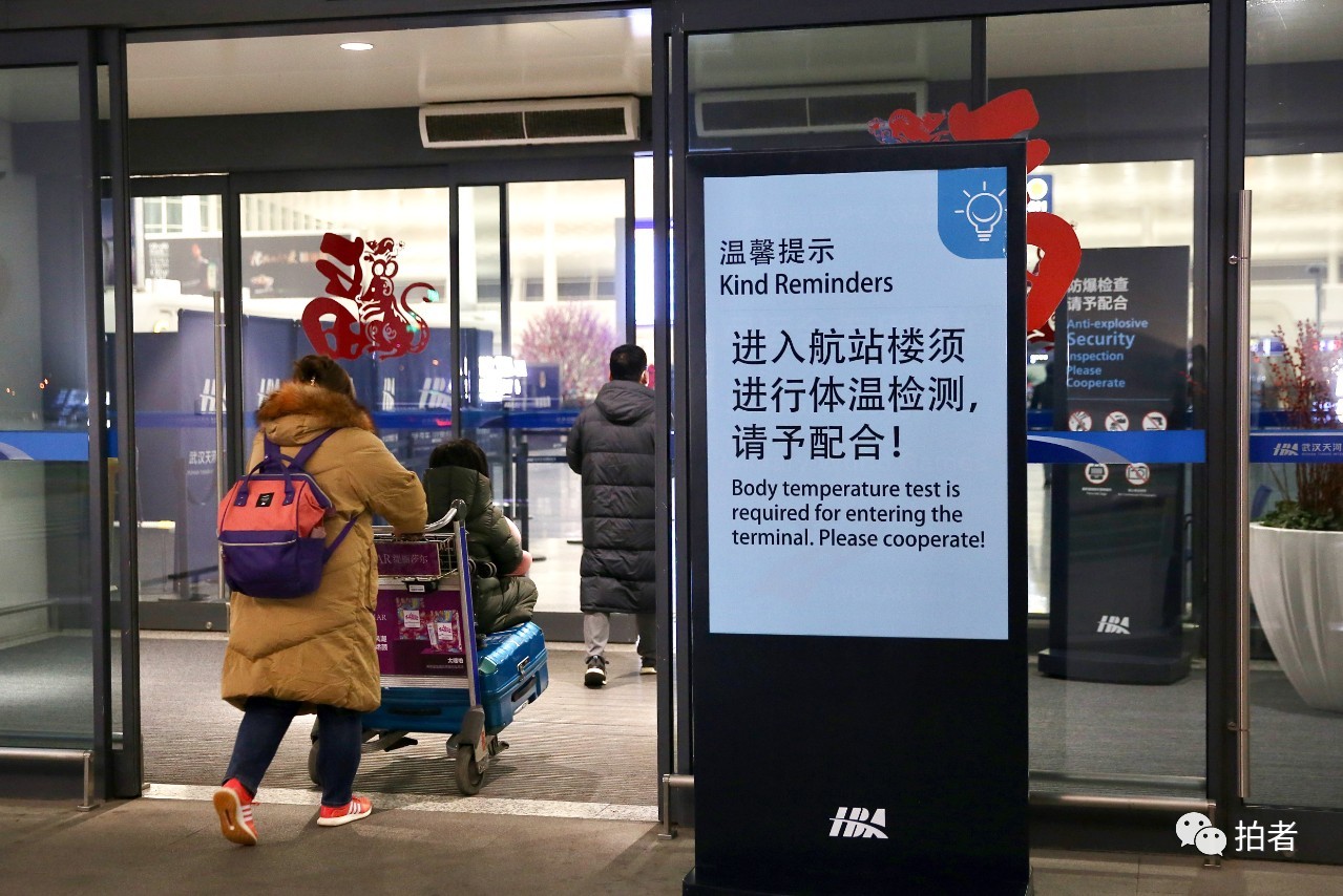 △ 1月23日,武汉天河国际机场航站楼外,立有体温检测提示牌。