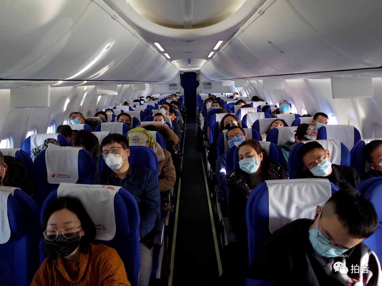 △ 1月22日,北京往武汉的飞机上,佩戴口罩的旅客们。