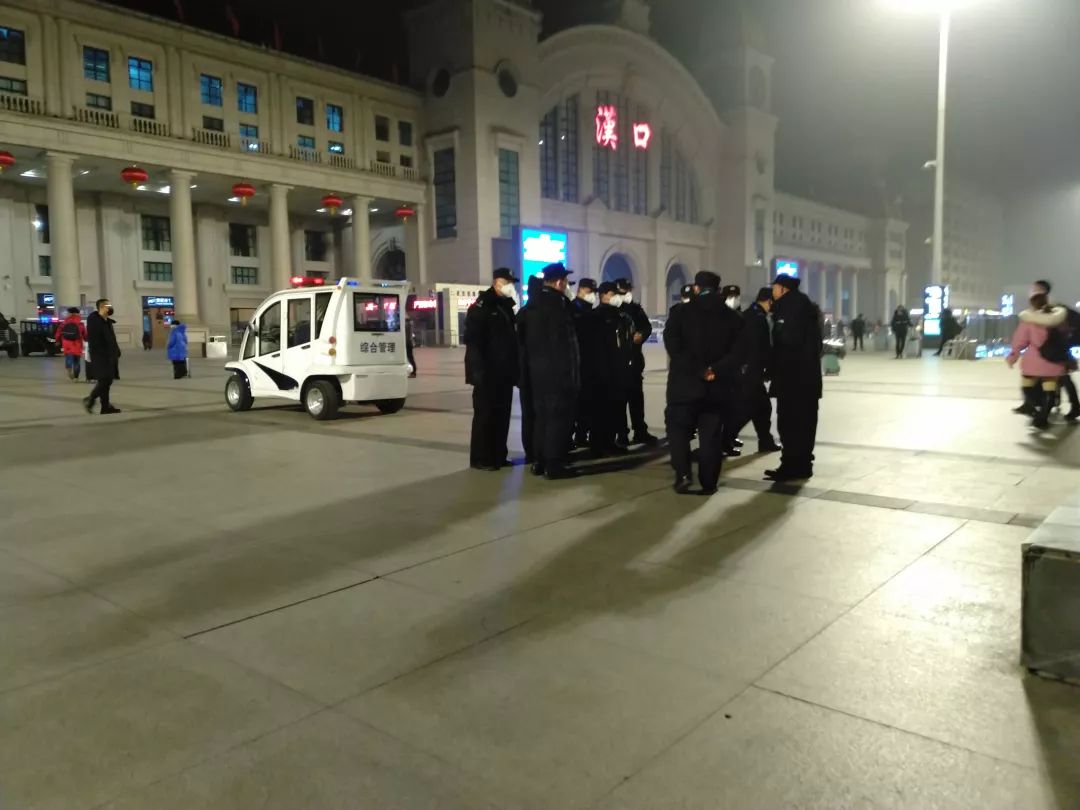 6时35分,汉口站广场上,一队警务人员正在开会。 新京报记者 海阳 摄