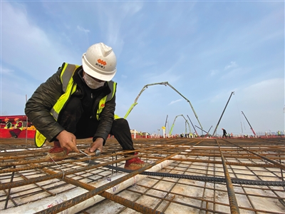 施工人员搭建钢筋结构,远处开始水泥浇筑。新京报记者 马骏 摄