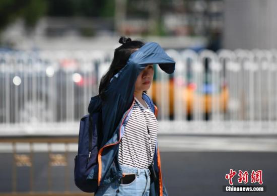 资料图:出行的市民用各种装备来遮挡炙热的阳光。中新社记者 张兴龙 摄