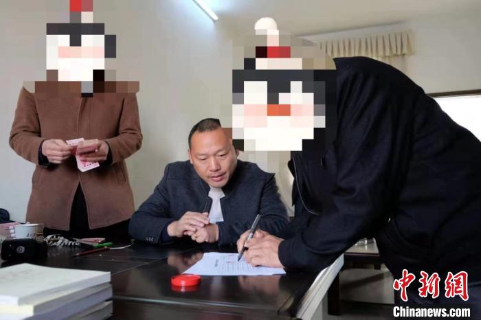 图为湖北省浠水县劳动保障监察局工作人员向农民工发放被拖欠工资 湖北省公安厅供图