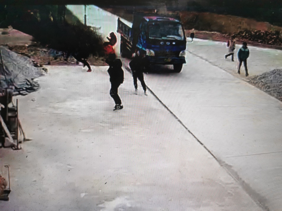  肇事农用车经过人群时的监控视频截图。