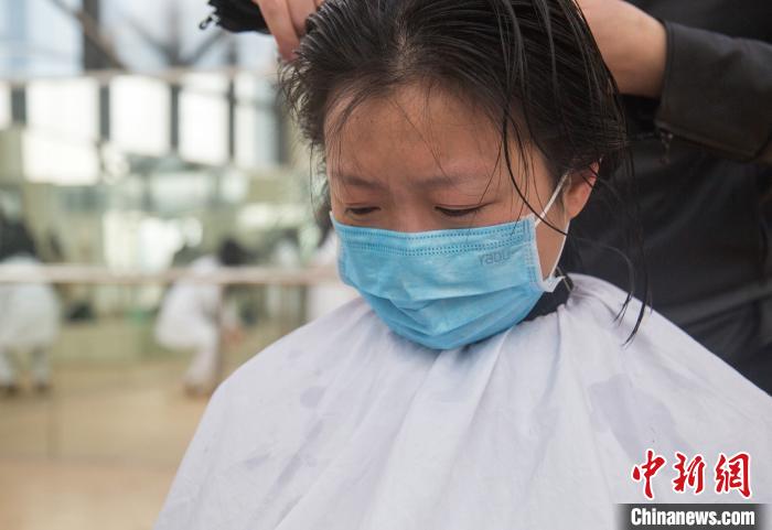 剪发时护士廖丽萍忍不住落泪。 王松平 摄