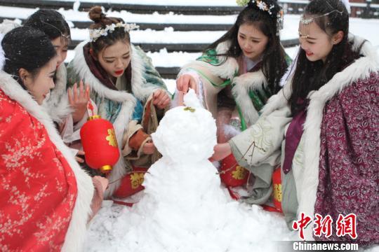 资料图:古装美女堆雪人。 戴佳阳 摄