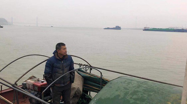 禁捕前,张船快站在渔船上,神情茫然。