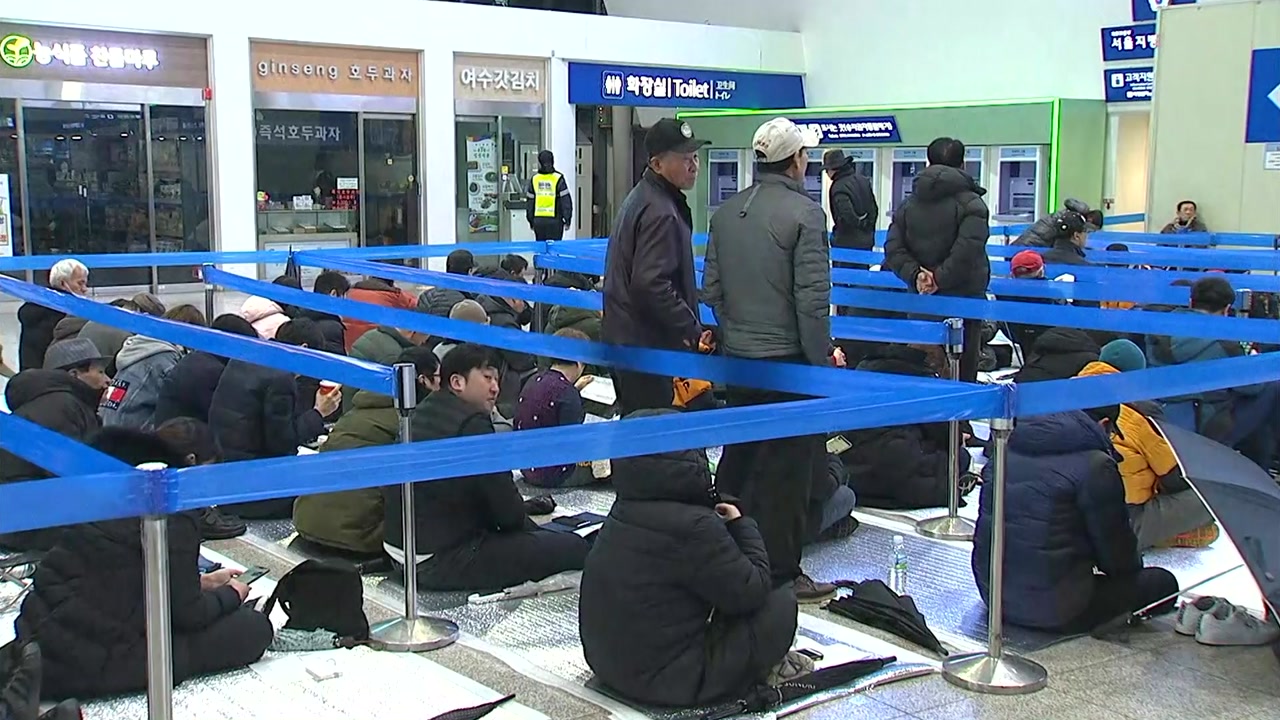 坐在保暖垫上排队购票的韩国市民（YTN电视台）