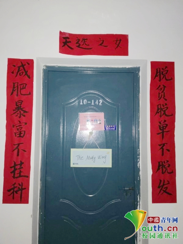 图为大学生在宿舍门口贴的创意春联“脱贫脱单不脱发,减肥暴富不挂科”。南昌工学院团委供