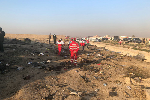  1月8日，在伊朗德黑兰郊外，救援人员在坠机现场查看。新华社/美联
