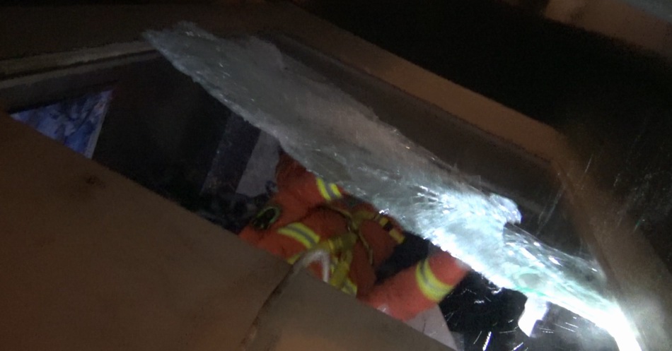 消防队员降至电梯井内部，敲碎观光电梯一面钢化玻璃。 本文图片 涪陵消防救援支队提供