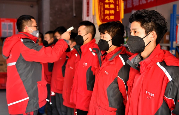 2月3日,陕西西安,京东快递在配货前集体测量体温。 新华社 图