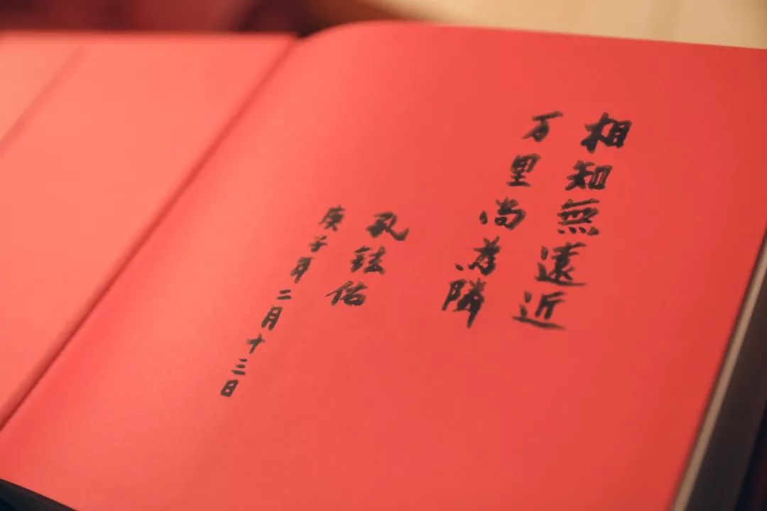 2月13日,中国驻日本大使孔铉佑向旗袍女孩赠送《中国世界遗产影像志》上的题字。新华社记者 杜潇逸 摄
