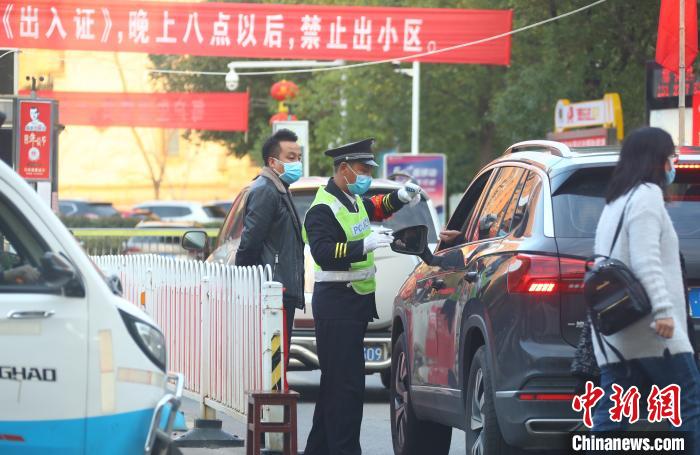 图为2月14日,江西省南昌市新建区一小区实施封闭式管理,对进出车辆司乘人员进行体温测量。 刘占昆 摄