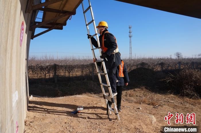 “90后”高铁桥梁“医生”班宜峰架梯准备爬入桥梁体。 沈忱 摄