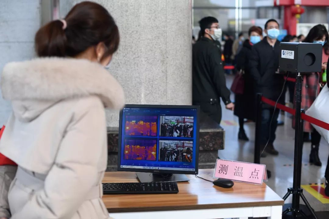 ▲2月18日,義烏國際商貿城工作人員站在紅外測溫儀旁查看進入市場中的商戶和客商的體溫。