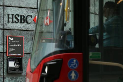 在英国伦敦,一辆公交车从英国汇丰银行门前经过。新华社发