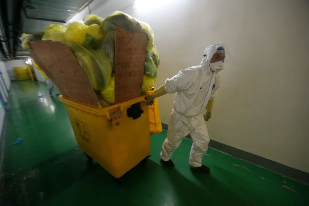 早上六点,武汉同济医院中法新城院区的工作人员开始上岗,清理住院楼内的医疗废物。(摄影:崔萌)