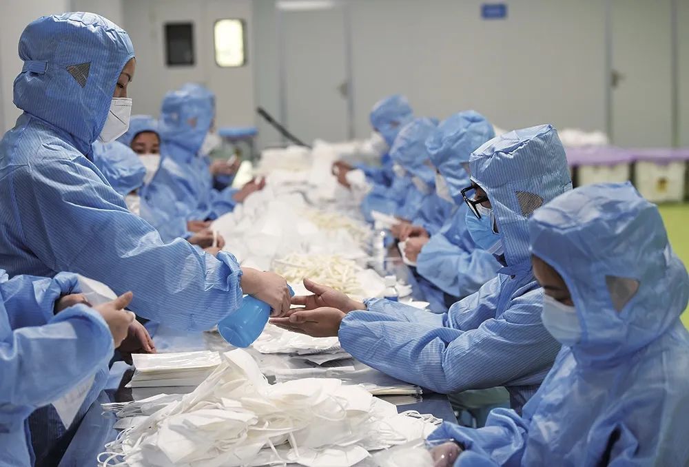 2月17日,在重庆一企业的N95医用防护口罩生产包装车间内,工作人员在作业间隙消毒。图/新华
