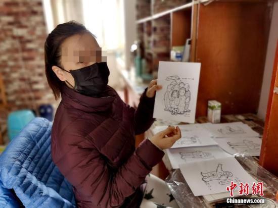 治愈出院患者展示本身创作的漫画。 安源 摄